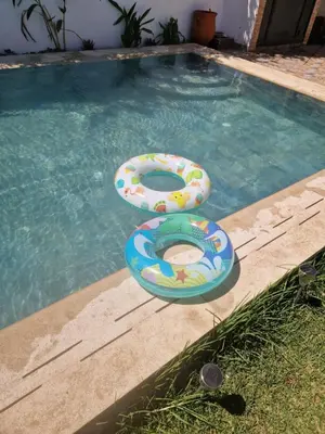 two inflatables are sitting in a swimming pool at Villa spacieuse avec piscine proche aéroport Mohamed V in Nouaseur