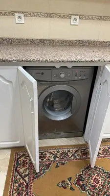 a washing machine under a counter with its door open at Spacious apartment in Settat