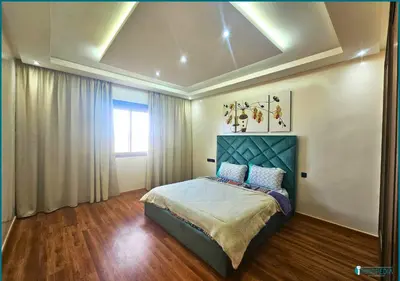 a bedroom with a bed with a blue headboard and a window at Une petite parenthèse marine in Mansouria