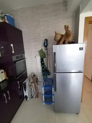 a kitchen with a stainless steel refrigerator in a room at Sunny apartment in El Harhoura