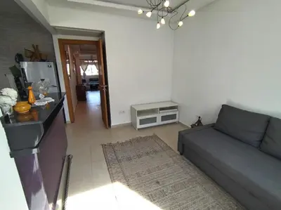a living room with a couch and a table at Sunny apartment in El Harhoura