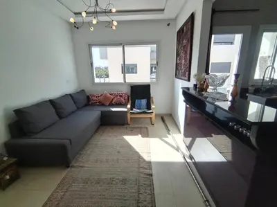 a living room with a couch and a table at Sunny apartment in El Harhoura