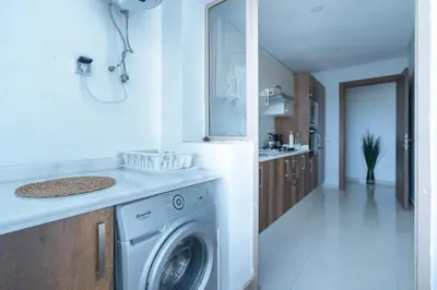 a kitchen with a washing machine in a room at Charming Flat with Pool view Fast Wi-Fi in Bouznika