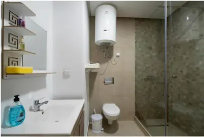 a bathroom with a shower and a toilet and a sink at Nice & Comfortable 2BHK panoramic balcony with swimming pool in Aïn Harrouda