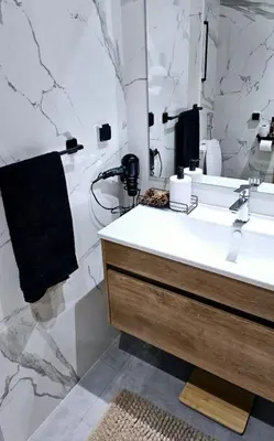 a white bathroom with a sink and a mirror at Appartement de Luxe - Gare Rabat Agdal in Rabat