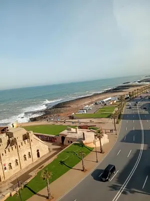 a road next to the ocean with a beach at Joumaira appartement Beach in Rabat