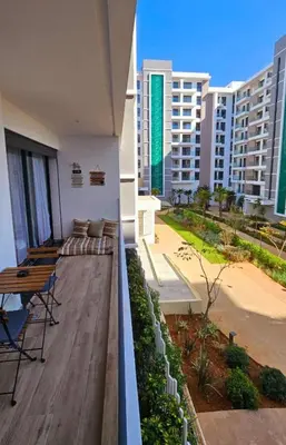 a balcony with a table and chairs and buildings at Cosy Appartement Rabat Agdal in Rabat