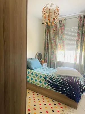 a bedroom with a bed and a chandelier at Jannat tamaris in Tamaris