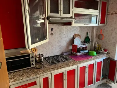 a kitchen with red and white cabinets and a stove at Appartement de luxe in Casablanca