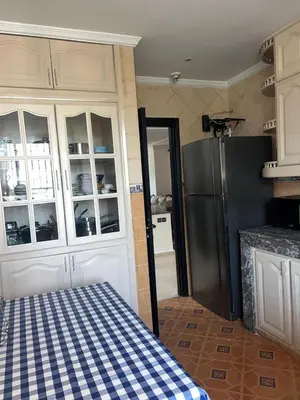a kitchen with a black refrigerator and white cabinets at Spacious and stylish apartment near stadium Moulay Abdellah in Rabat