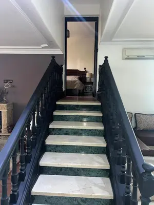 a stairway leading to a room with a bed at Spacious and stylish apartment near stadium Moulay Abdellah in Rabat