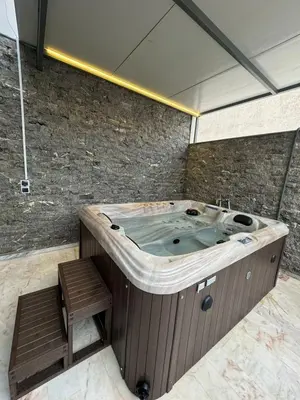 a large bath tub in a room with two wooden steps at RÉSIDENCE LE BIjOU DE L'AGDAL in Rabat