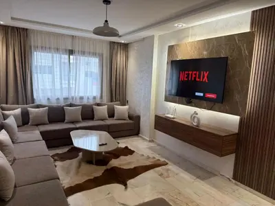 a living room with a couch and a tv at RÉSIDENCE LE BIjOU DE L'AGDAL in Rabat