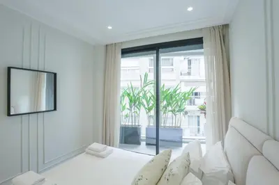 a white room with a bed and a large window at Résidence Claridge Racine in Casablanca