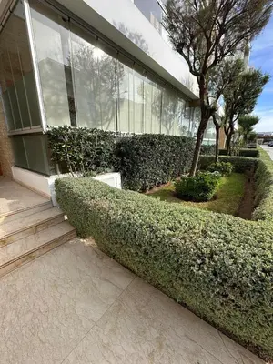 a building with green bushes in front of a building at Peninsula Dar Bouazza in Tamaris