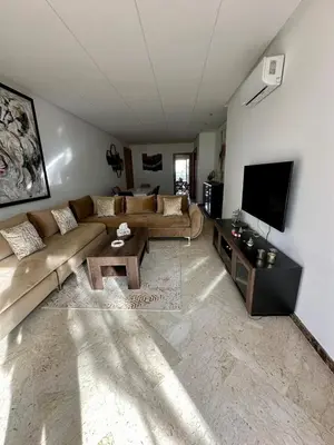 a living room with a couch and a tv at Peninsula Dar Bouazza in Tamaris