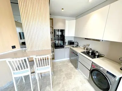 a kitchen with a washing machine and chairs in it at TheBesty Ocean Suite -By Appart'Ayla in Anfa-Supérieur