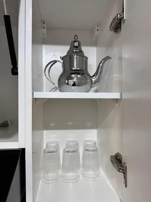 a shelf with glasses and a tea kettle on it at Elegant 3BR Stay 5min to Hay Riad in Temara