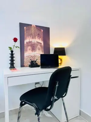 a desk with a chair and a laptop on it at Elegant 3BR Stay 5min to Hay Riad in Temara