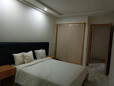 a bedroom with a large bed and a closet at Bati d or in Mohammedia