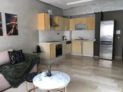 a kitchen and living room with a couch and a table at Cosy C35 in Casablanca