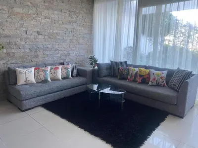 a living room with two couches and a brick wall at Melrose beach apartment in Tamaris
