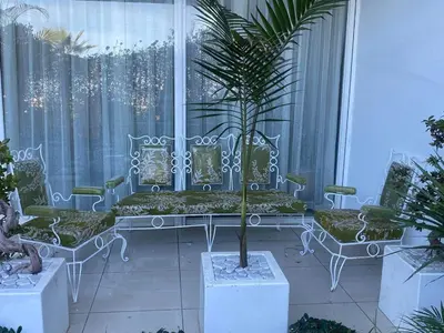 a balcony with a white bench and a palm tree at Melrose beach apartment in Tamaris