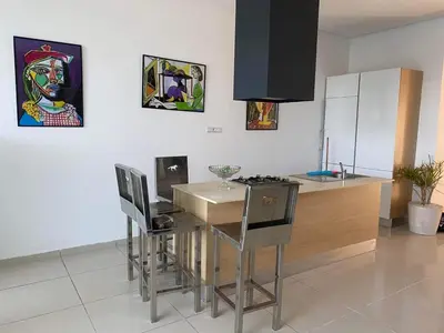 a kitchen with a table with chairs and a counter at Melrose beach apartment in Tamaris