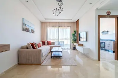 a living room with a couch and a table at Appartement Sublime avec Piscine in Mansouria