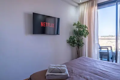 a bedroom with a bed and a tv on the wall at Appartement Sublime avec Piscine in Mansouria