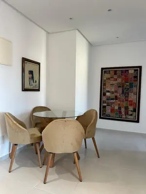 a dining room with a glass table and chairs at Bel Appartement à Harhoura pour les familles in El Harhoura