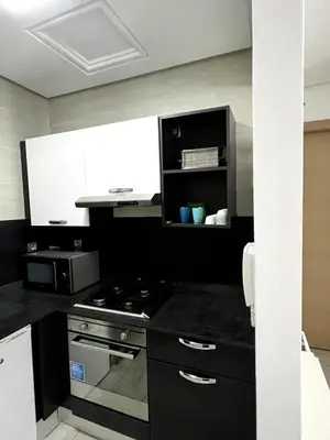 a kitchen with a stove and a microwave at 1 bed apt In Prestigia hay Riad rabat in Rabat