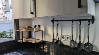 a kitchen with utensils hanging from a wall at Appt neuf Zenata- 2 chambres et Mezzanine - Piscine in Aïn Harrouda
