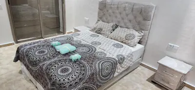 a bedroom with a bed with a gray and white comforter at Appartement ALAA - Malaga beach in Mansouria