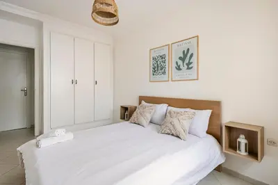 a white bedroom with a large white bed with pillows at Rabat Centro Apartments in Rabat