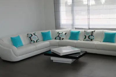 a living room with a white couch with blue pillows at Eden Island Villa - Bouznika in Bouznika