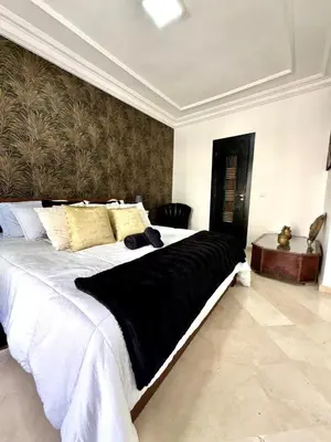 a bedroom with a large bed with a black blanket at Oumadane Appart-Ocean view- Amazing apartment-International Fair and more near by in Casablanca