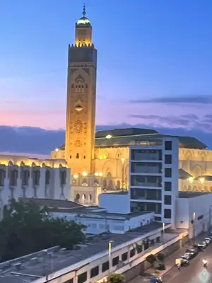 a large building with a clock tower at night at Oumadane Appart-Ocean view- Amazing apartment-International Fair and more near by in Casablanca
