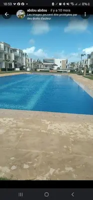a large swimming pool in front of a building at Appartement Alaa in Mansouria