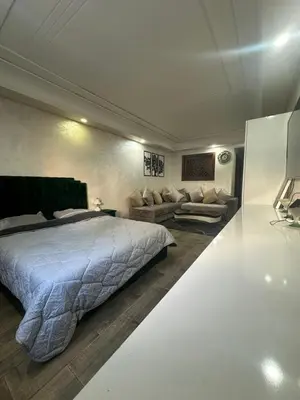 a bedroom with a large bed and a couch at شقة فأكدال in Rabat
