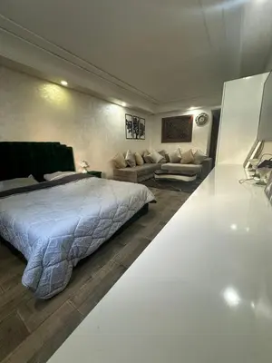 a large bedroom with a bed and a couch at شقة فأكدال in Rabat