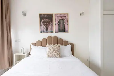a bedroom with a large bed with white sheets at Spacious 2Bedrooms Fully equipped-5min Agdal Station in Rabat