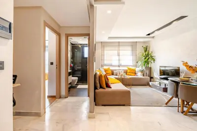 a living room with a couch and a table at Studio Cosy, corniche à 2 min , Parking , Netflix in Casablanca