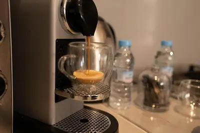 a coffee maker is making a drink in a cup at Studio Cosy, corniche à 2 min , Parking , Netflix in Casablanca