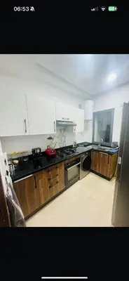 a kitchen with wooden cabinets and a stainless steel appliances at Beautiful Apartment with Seaside Pool in Mansouria