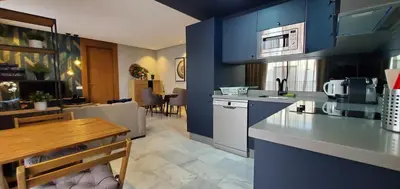 a kitchen and living room with blue walls and a table at Luxurious apartment casablanca in Casablanca