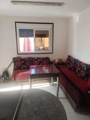 a living room with a red couch and a table at Sense house 2 in Rabat