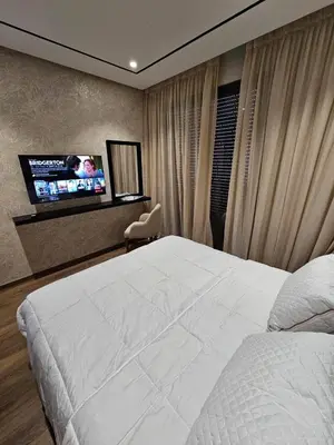 a bedroom with a white bed and a flat screen tv at Studio Seven Sky 1 - Close to CFC in Casablanca