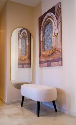 a stool in a room with two paintings on the wall at Charming 2 Bedroom Casavoyageur in Casablanca