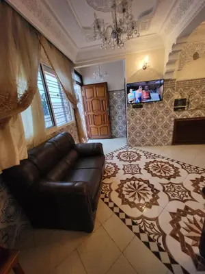 a living room with a leather couch and a door at Maison 2pc plain-pied -centre in Rabat